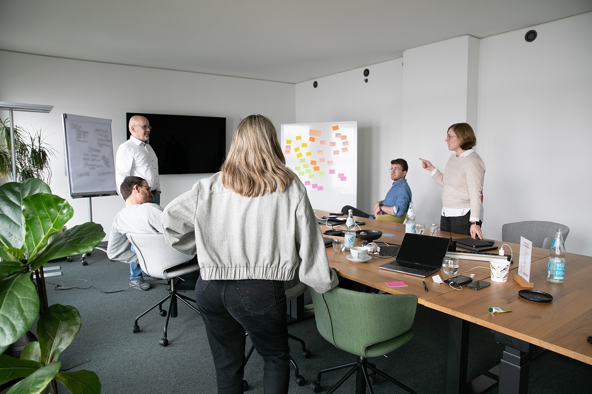 Team folgt Erläuterungen am Whiteboard im Meeting